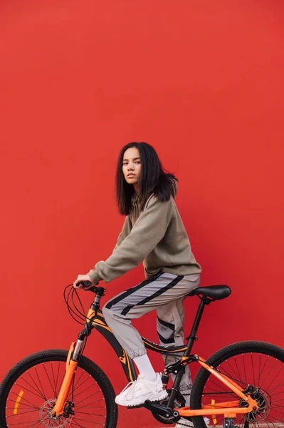 Retrato Jovem Mulher Atraente Bicicleta Isolado Fundo Vermelho Olhando Para — Fotografia de Stock