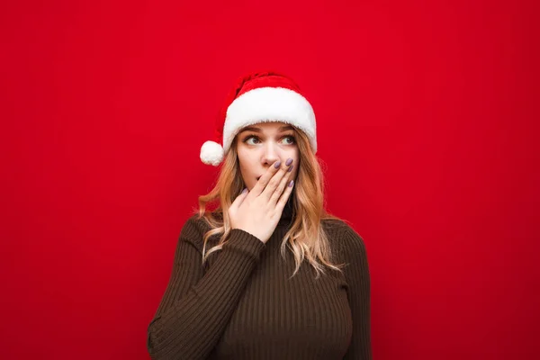 Sorpresa Ragazza Maglione Caldo Erge Uno Sfondo Rosso Cappello Natale — Foto Stock