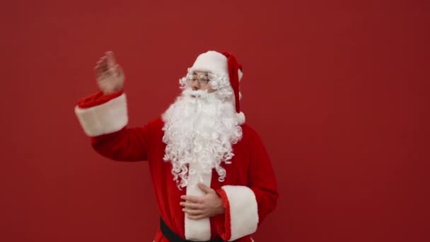Happy Santa Στέκεται Ένα Κόκκινο Φόντο Χαμογελώντας Και Δείχνοντας Προς — Αρχείο Βίντεο