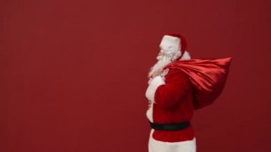 Kafası karışmış bir Noel Baba, sırtında bir torbayla çerçeveye girer ve kargaşa içinde etrafına bakar ve çerçeveyi terk eder. Kırmızı bir arka planda Bulmaca Noel Baba.