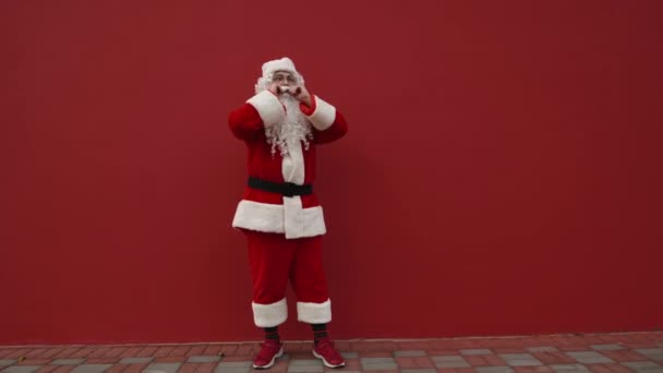 Grappige Santa Dansen Straat Een Achtergrond Van Een Rode Muur — Stockvideo