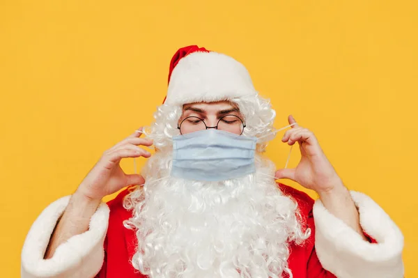 Porträt Des Lustigen Weihnachtsmannes Mit Medizinischer Schutzmaske Auf Gelbem Hintergrund — Stockfoto