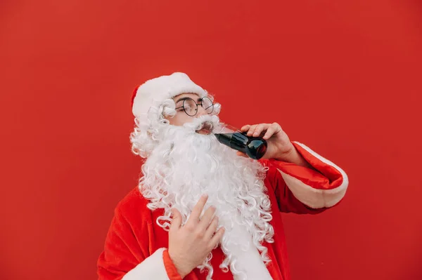 Jultomten Står Bakgrund Röd Vägg Dricka Cola Med Flaska Med — Stockfoto