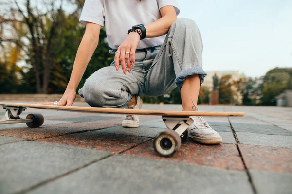 Kontekst Przycięte Zdjęcie Bliska Kobieta Ulicznym Ubraniu Siedząca Chodniku Longboardem — Zdjęcie stockowe