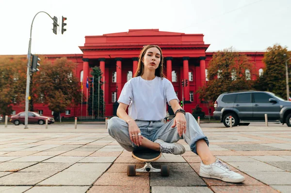 Stylische Frau Sitzt Auf Einem Longboard Vor Straßenhintergrund Und Posiert — Stockfoto