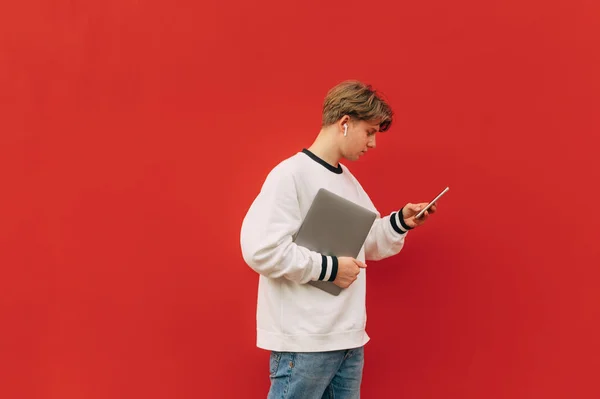 Concentrated Young Man Casual Clothes Headphones Walks Background Red Wall — Stock Photo, Image