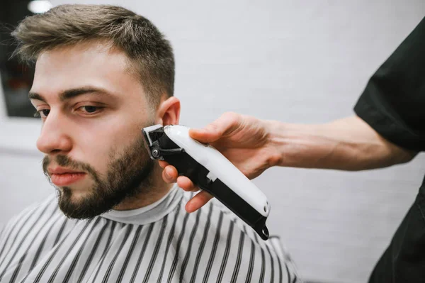 Friseurhand Mit Haarschneidemaschine Schneidet Einem Bärtigen Mann Die Haare Nahes — Stockfoto