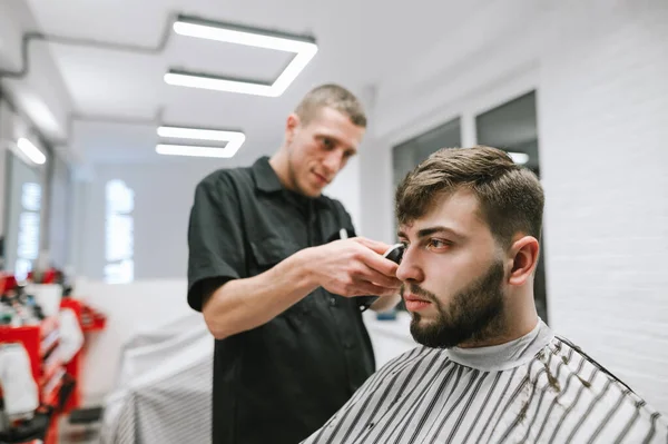 Ritratto Cliente Maschio Barbuto Seduto Una Sedia Accovacciato Barbiere Distolgendo — Foto Stock