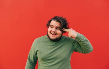 Çılgın, komik, genç, İspanyol bir adam ateş eden bir jest yapıyor, şaka yapıyor ve gülümsüyor, komik ve sinirli oluyor, stresin üstesinden gelmeye çalışıyor..