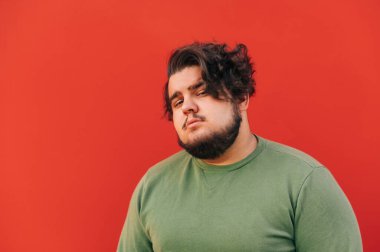 Yakından bakınca, kıvırcık saçlı, yakışıklı bir İspanyol sakallı genç adam şüpheli bir şekilde kameraya bakıyor, baştan çıkarıcı oluyor..