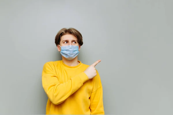 Young Man Protective Mask Serious Face Stands Background Gray Wall — Stock Photo, Image