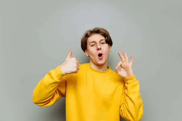 Vrolijke Man Casual Kleding Staat Een Achtergrond Van Een Grijze — Stockfoto