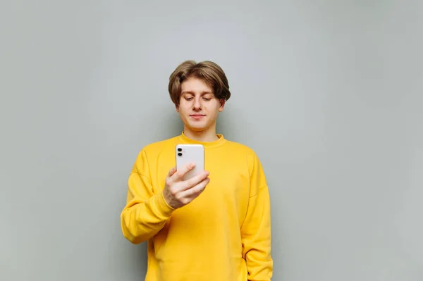 Schöner Junger Mann Benutzt Ein Smartphone Auf Grauem Hintergrund Mit — Stockfoto