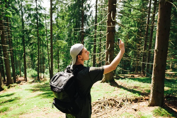 Sırt Çantalı Genç Bir Adam Dağlarda Elinde Akıllı Bir Telefonla — Stok fotoğraf