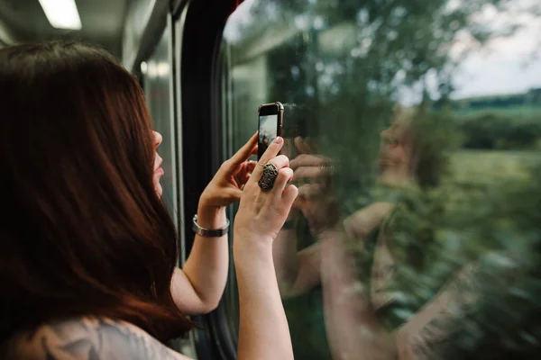 Женщина Стоящая Коридоре Поезда Фотографирует Красивый Пейзаж Окна Смартфоне — стоковое фото