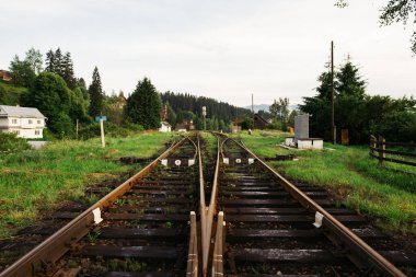 Dağlardaki paslı raylı eski tren istasyonu. Ulaşım demiryolu konsepti. Vorokhta, Ukrayna.