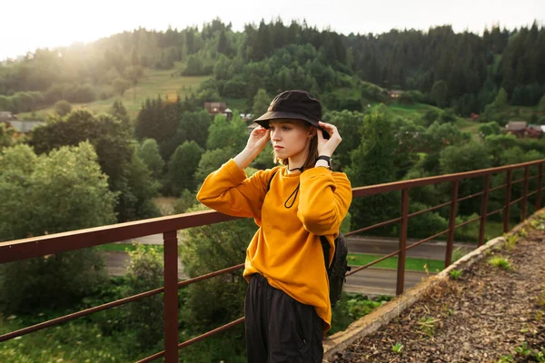 Portrait Attractive Female Hiker Orange Sweatshirt Hat Standing Bridge Mountains — Stock Photo, Image