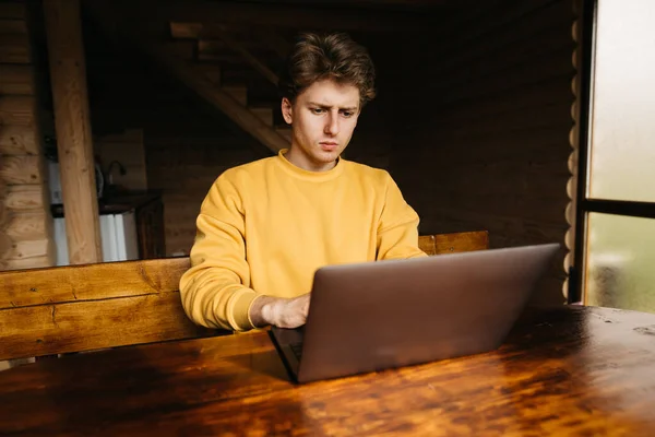 Hombre Freelancer Joven Concentrado Suéter Naranja Sentado Mesa Habitación Con — Foto de Stock