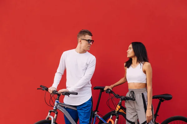 Kırmızı Duvar Arka Planında Izole Edilmiş Bisiklet Süren Bindikten Sonra — Stok fotoğraf