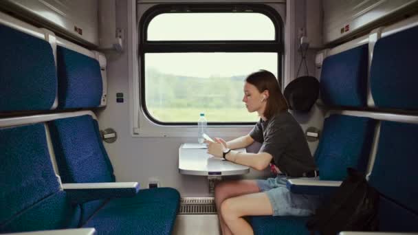 Hermosa Turista Femenina Auriculares Inalámbricos Escucha Música Viaje Tren Utiliza — Vídeo de stock