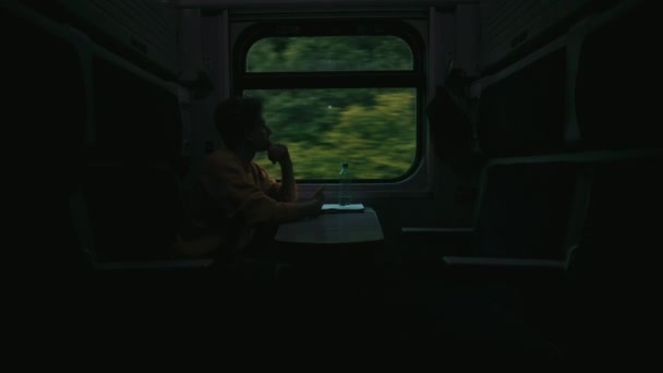 身穿休闲装的年轻人开车时坐在窗边的一辆夜车上 用的是一张严肃的面孔智能手机 — 图库视频影像
