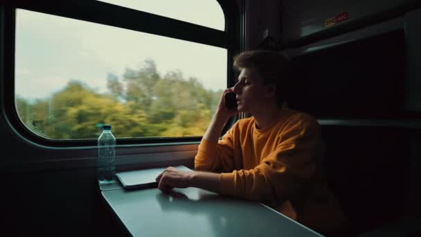 Joven Viaja Tren Habla Por Teléfono Con Una Persona Seria — Vídeo de stock