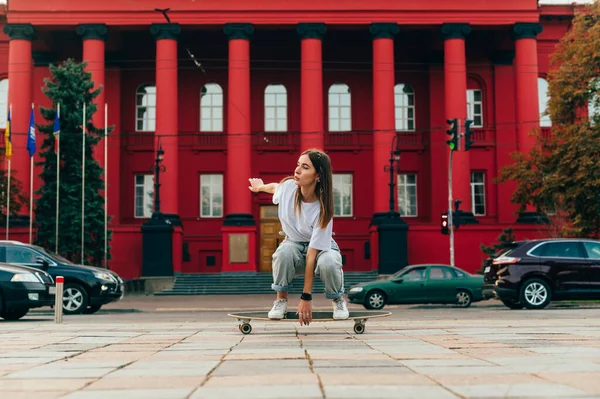Premium Photo  Vertical fulllength photo of a stylish skater woman in casual  baggy clothes holding a longboard