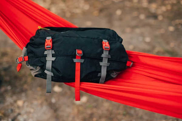 Travel waist bag lies on a red hammock in the woods. Advertising photo of waist bags