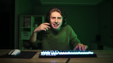 Genç adam bir video oyunu kaybediyor ve yüzünü utançla örtüyor. Kulaklık takmış üzgün bir oyuncu yeşil bir odada bilgisayarın başına oturur ve oyunu kaybettikten sonra ağlar..