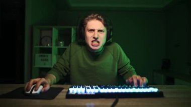 Siber atlet evde bilgisayar başında antrenman yapar, evde bir masada kulaklıkla oturur ve ekrana konsantre olur ve video oyunları oynar. E-spor.