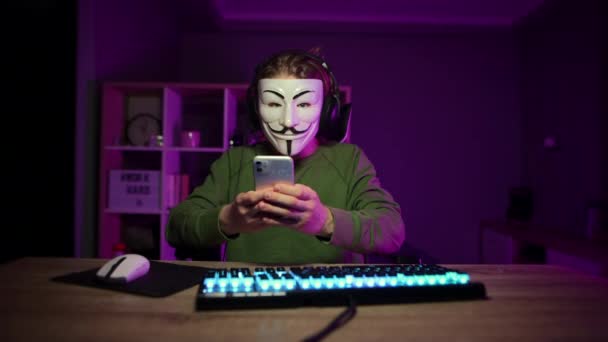 Mann Anonymer Maske Sitzt Nachts Computer Zimmer Und Benutzt Smartphone — Stockvideo