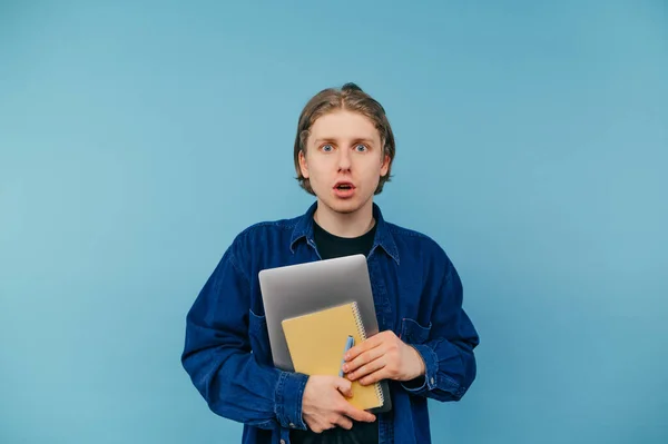 Überraschter Junger Student Mit Laptop Und Notizbuch Steht Auf Blauem — Stockfoto