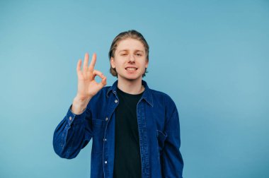 Handsome guy in casual clothes shows gesture 