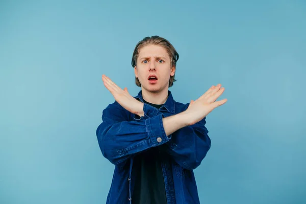 Portrait Dissatisfied Guy Shirt Stands Blue Background Crosses His Arms — Foto Stock