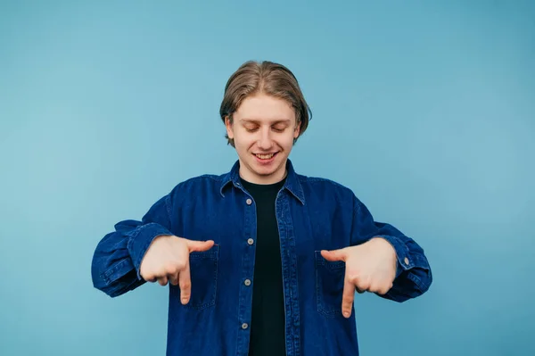 Pozytywny Student Koszuli Stoi Niebieskim Tle Pokazuje Swoje Palce Wskazujące — Zdjęcie stockowe