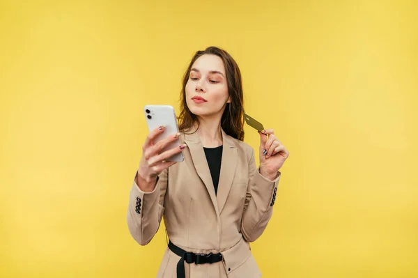 Mujer Atractiva Traje Pie Sobre Fondo Amarillo Con Teléfono Inteligente — Foto de Stock