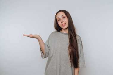 Woman in gray t-shirt gesturing with open palm