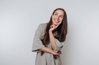 A smiling woman in a gray shirt posing against a plain background.