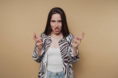 Woman in zebra print shirt making a fierce expression against a beige background.