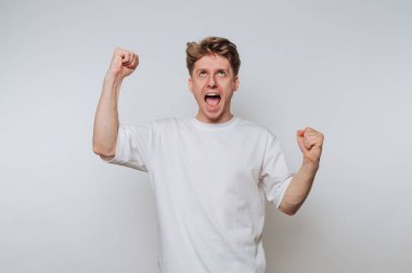 Excited man celebrating with fists raised in white t-shirt