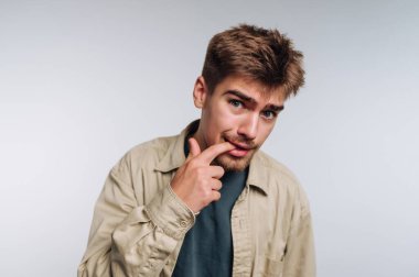 Delikanlının portresi derin düşüncelere ve beyaz arka plandaki iç gözlem anlayışına dayanarak, derin düşüncelere dokunarak derin düşüncelere dalmıştır.