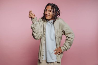 Genç bir adamın portresi neşeli bir tavır sergiliyor. Neşeli bir anı yakalıyor ve pembe arka planda neşeyi ifade ediyor.