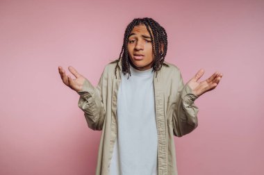 Belirsizlikle hareket eden genç adam portresi, karmaşa içinde yükselen kollar, pembe arka planda insani duyguları daha iyi gösteren.