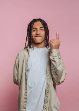 Genç adamın portresi özgüvenle yukarı doğru işaret ediyor. Hevesini ve pembe arka planda bir aydınlanma hissi var.