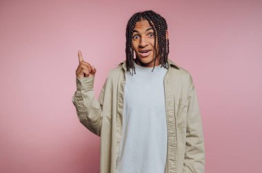 Genç adamın portresi şaşkın bir ifadeyle, pembe arka plandaki coşku ve ilhamı aktarıyor.