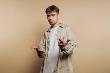 Genç adamın portresi farklı duygular gösterir. Bej arka planda karmaşa, şaşkınlık ve mutluluk yakalarlar.