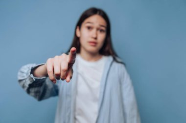 Mavi arka planda kameraya bakan genç bir kadın..