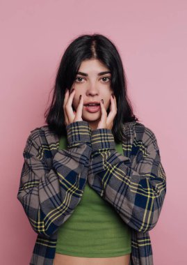 Pembe arka plana karşı şaşırmış genç bir kadın.