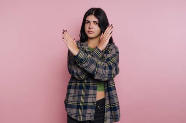 Pembe arka planda çapraz kollu bir kadın.