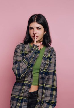 Dudaklarında parmak olan genç bir kadın..